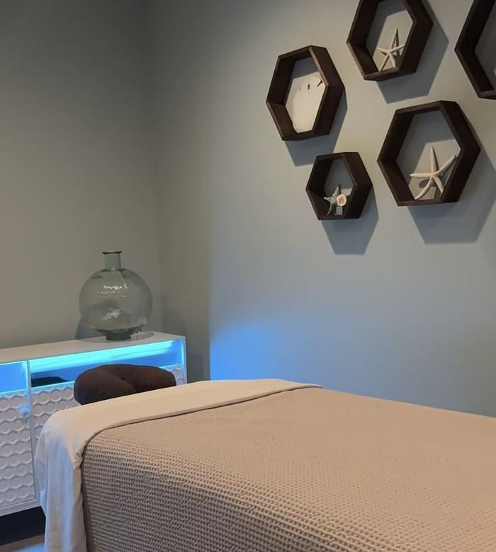Massage room with a made-up treatment bed and soft lighting